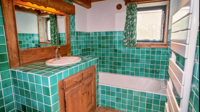 Salle de bain verte avec baignoire